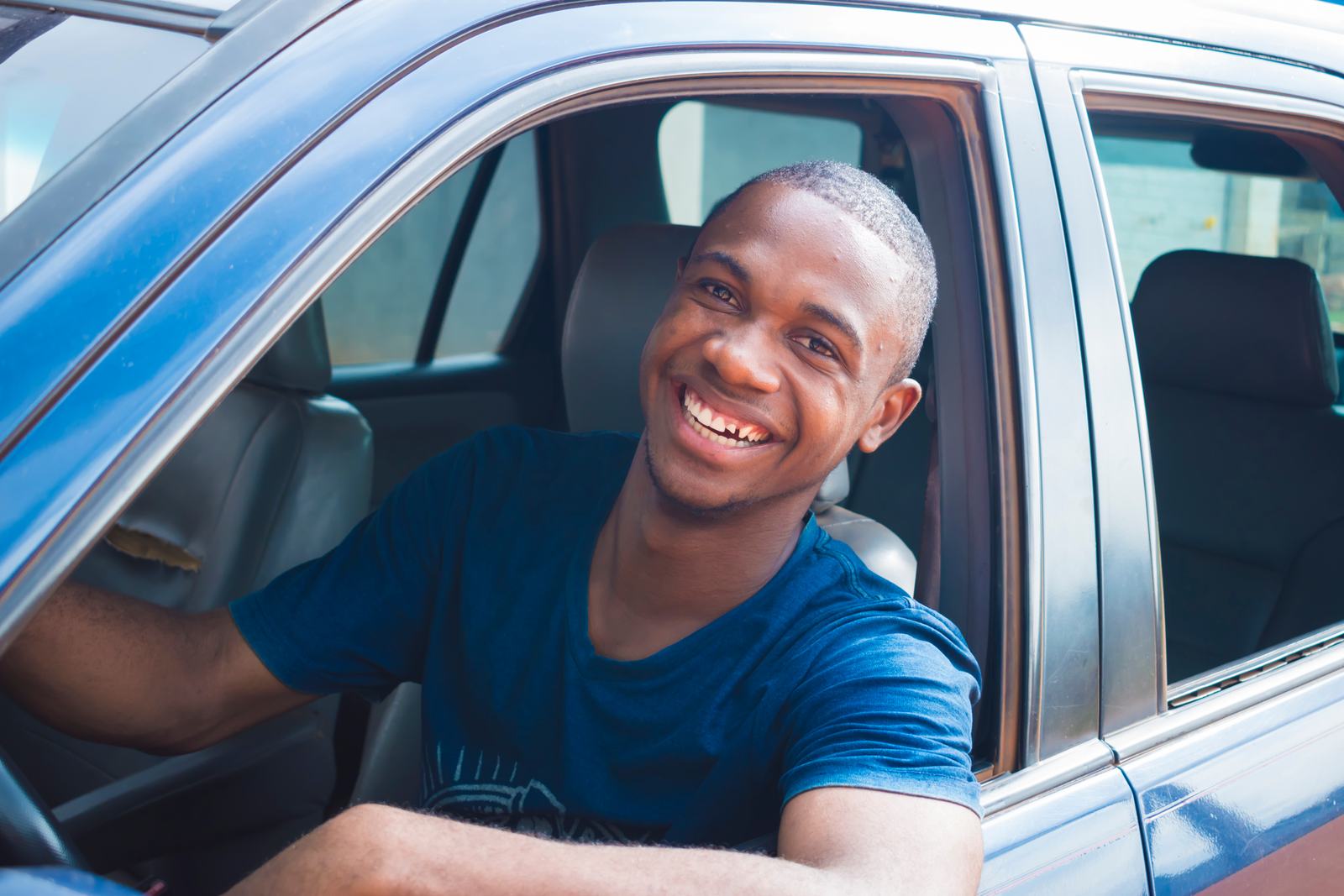 A smiling RideToGo driver at the wheel