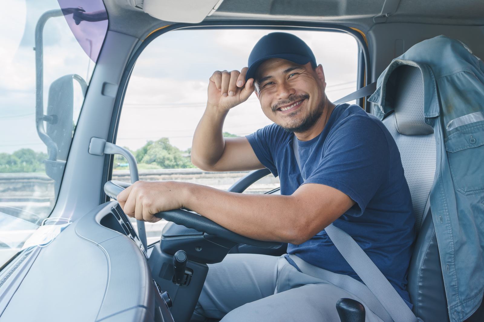 A smiling driver at the wheel of his van